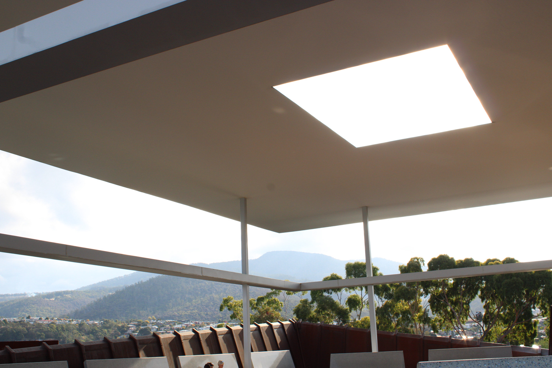 A wide architectural roof structure opening toward a mountain landscape